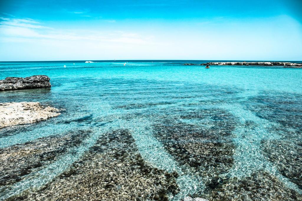 een strand met helder blauw water en rotsen bij Casa Nenè in Otranto