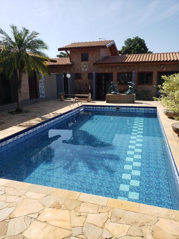 a swimming pool in front of a house at Suítes Verano Ubatuba - NOVAS - Bairro de Itaguá com piscina in Ubatuba