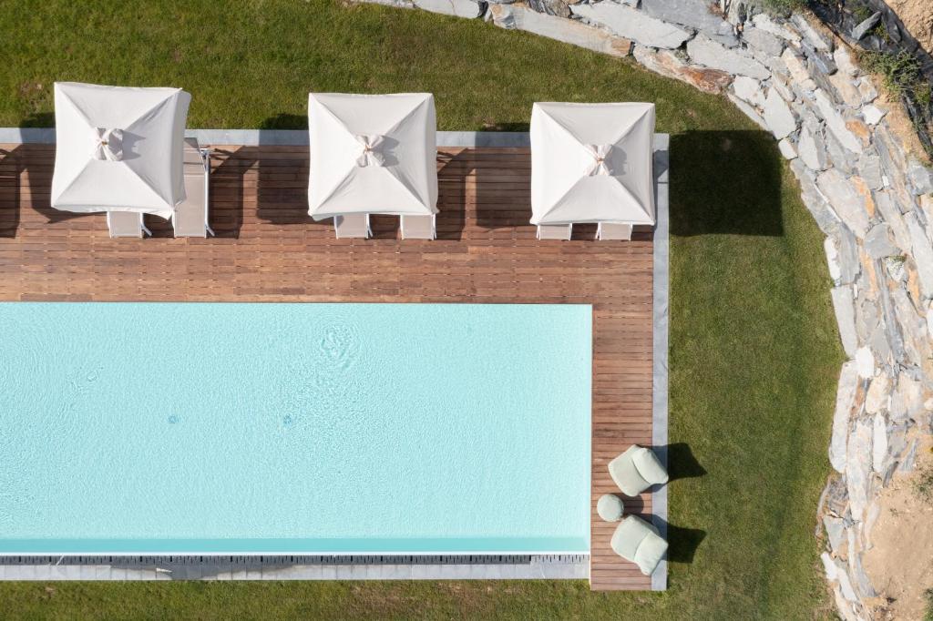 een uitzicht op vier stoelen en een zwembad bij La Colombiera Relais in Castelnuovo Magra