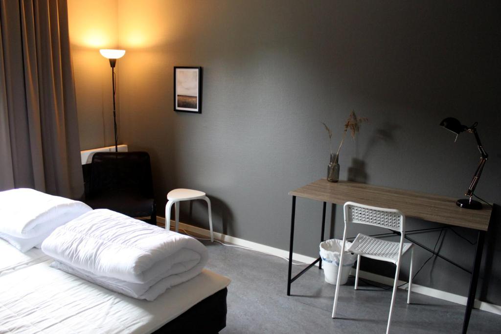 a bedroom with a bed and a desk and chairs at De la Gardie Park Vandrarhem Hostel in Lidköping
