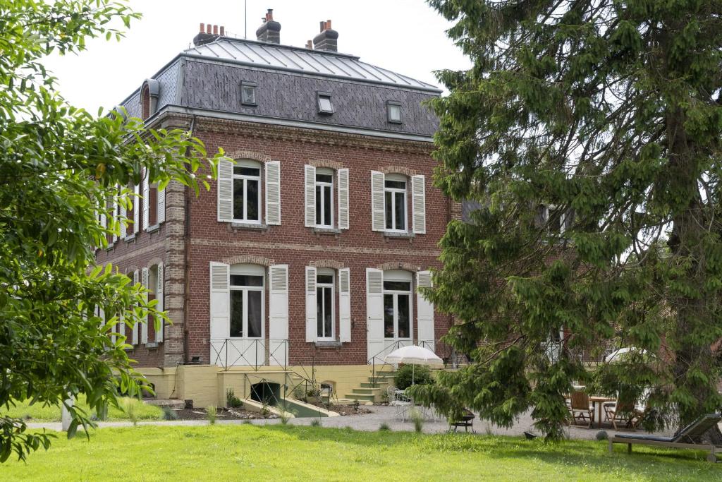 un grand bâtiment en briques rouges avec un toit dans l'établissement Domaine Les Tilleuls, à Wailly-Beaucamp