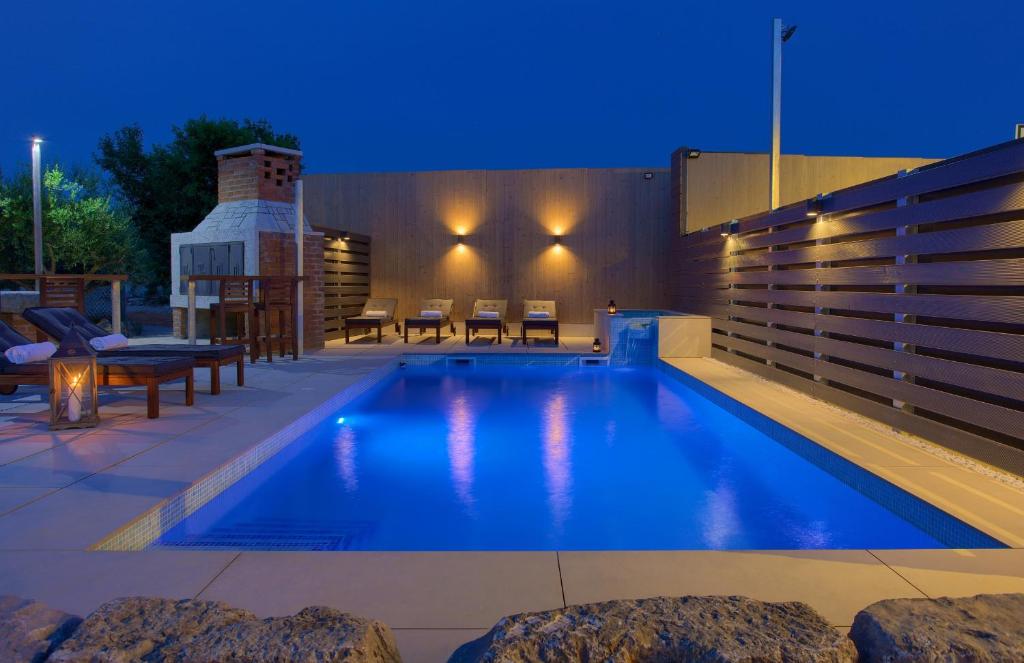 a swimming pool in a backyard at night at Villa Dora in Bajčići