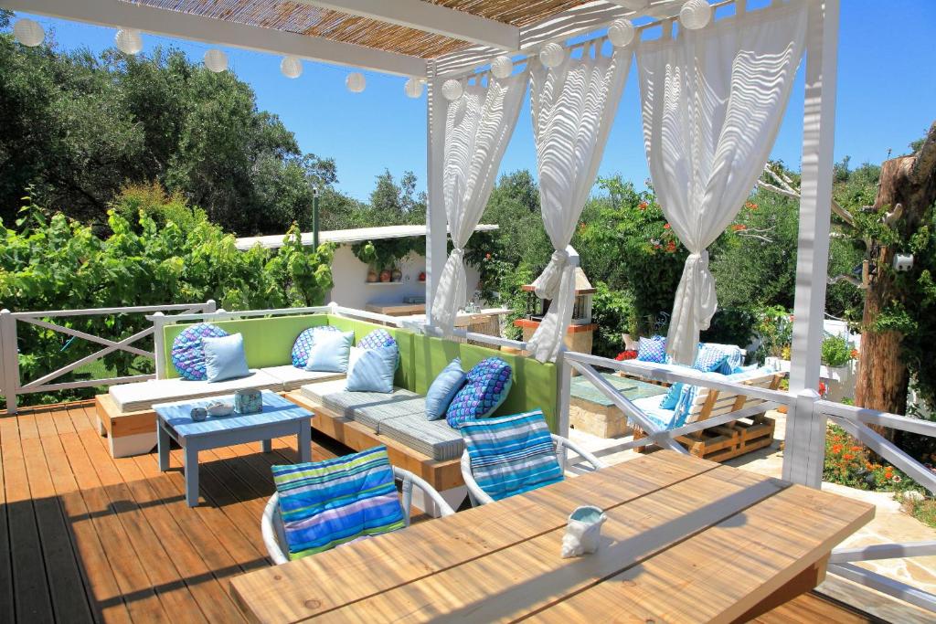 a patio with blue and white furniture on a deck at BLUE SKY COTTAGE, Kanouli beach in Halikounas