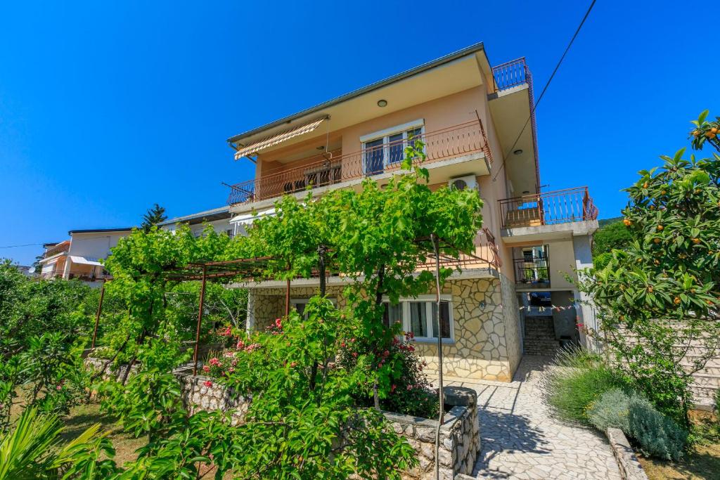 a house on a hill with plants at Apartments Melita in Dramalj