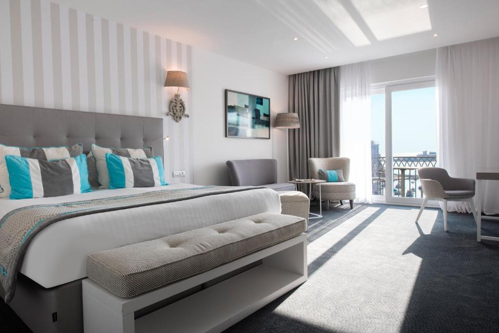 a bedroom with a large bed and a living room at Hotel Juliani - Boutique Hotel in St. Julianʼs