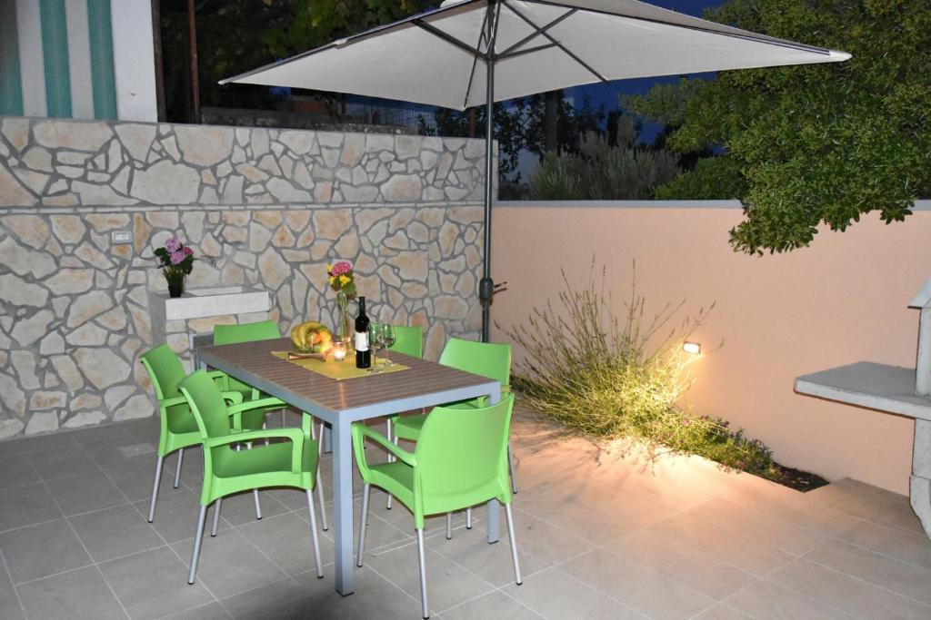 een tafel en stoelen met een parasol op een patio bij NEW Holliday House Ardura in Štivan