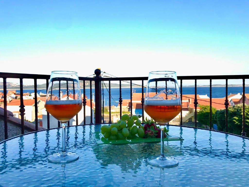 zwei Gläser Wein auf einem Tisch auf einem Balkon in der Unterkunft VIVIENDA CORRUBEDO VISTA DUNAS in Corrubedo