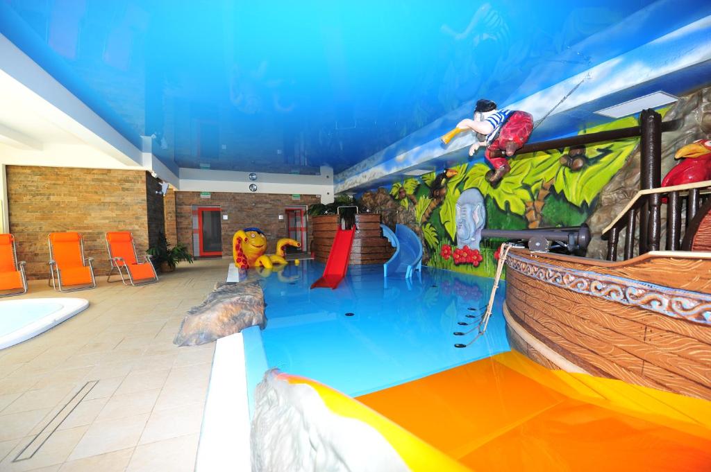 a large indoor water park with a water slide at Arenia Łeba -Filia Kompleksu ARENA SŁOŃCA in Łeba
