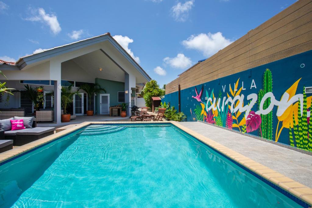 a swimming pool with a mural on the side of a house at Villa Curazon met privézwembad vlakbij het strand! in Jan Thiel