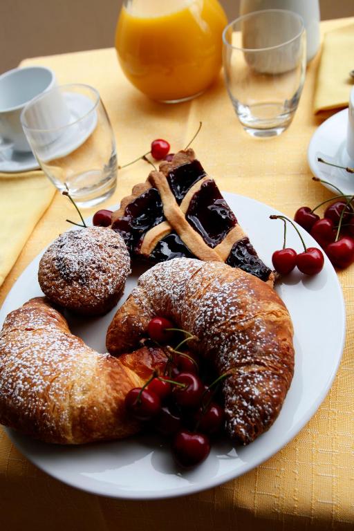 a white plate with pastries and cherries on a table at Bikini Hotel in Vieste