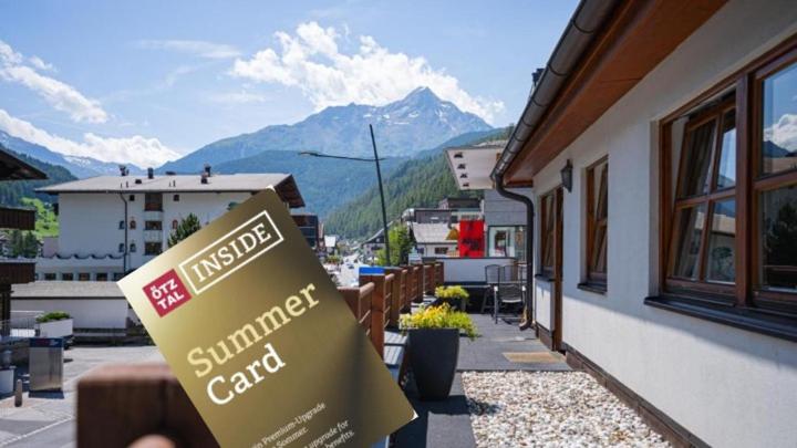 a sign in front of a building with mountains in the background at Apart Life in Sölden