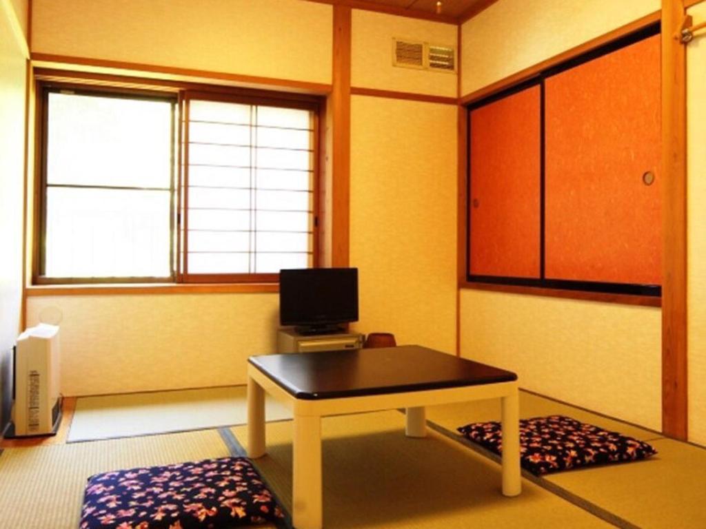 a room with a table and a tv in it at Oyado Fubuki - Vacation STAY 45506v in Nozawa Onsen