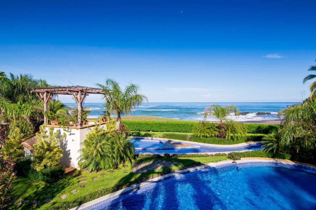 una vista aérea de una piscina con el océano en el fondo en Casa Cala Honda, en Playa Junquillal