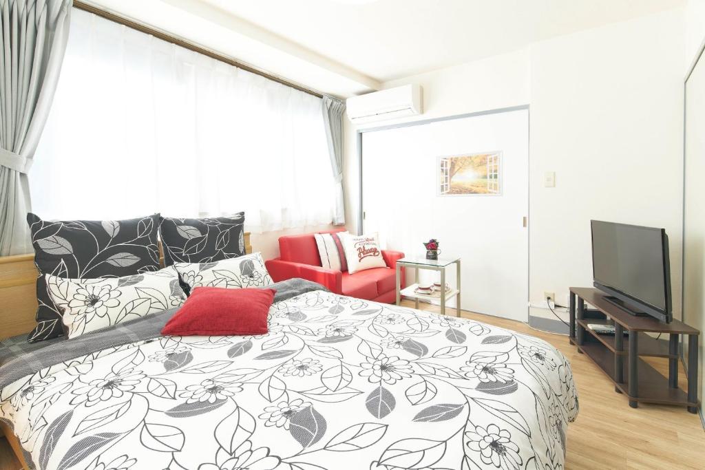 a bedroom with a black and white bed and a television at La Casa Esperanza - Vacation STAY 48389v in Tokyo