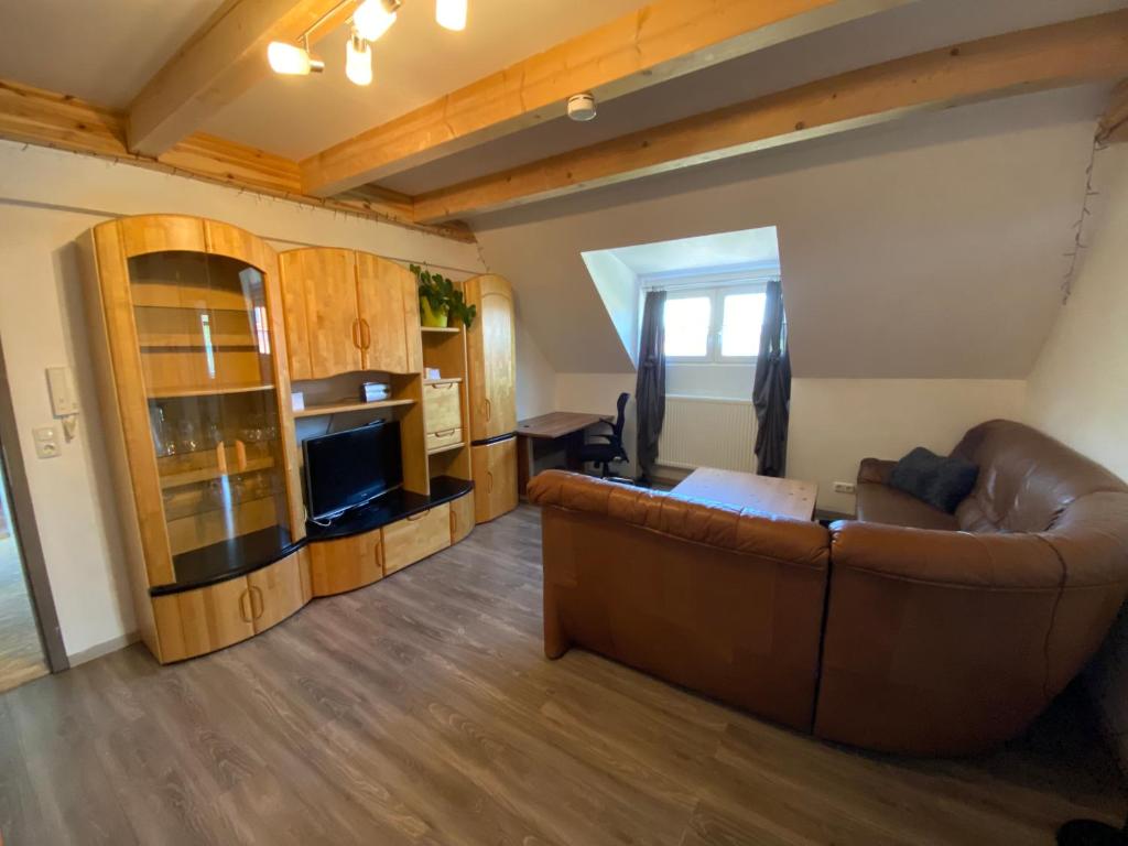 ein Wohnzimmer mit Ledercouch und Fernseher in der Unterkunft Casa Andrea 4 Zimmer Wohnung in Wallersdorf
