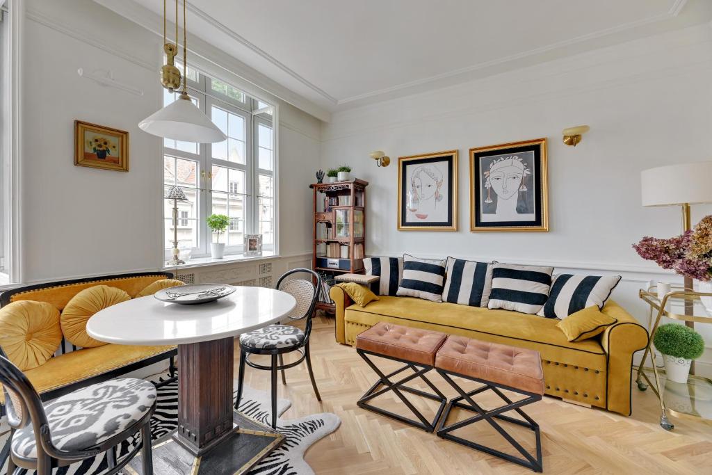 a living room with a yellow couch and a table at Dom & House - Old Town Swietego Ducha in Gdańsk