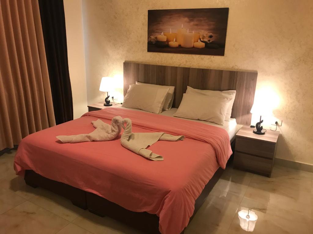 un animale di peluche che giace su un letto in una camera da letto di Suzan Hotel Apartments ad Amman