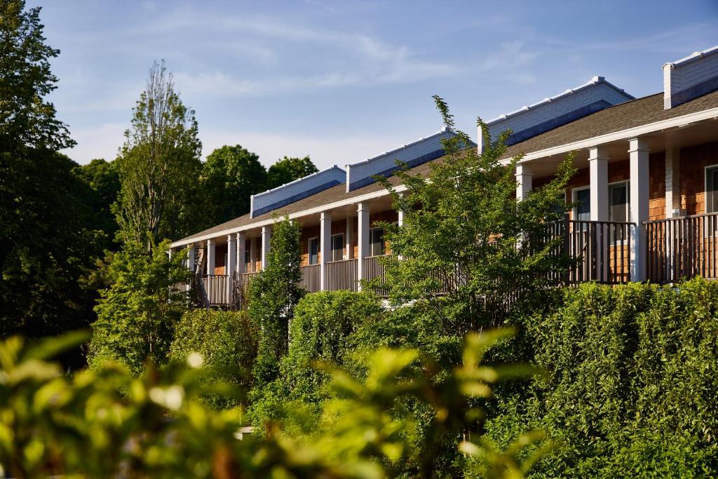 un edificio con arbustos delante de él en Journey East Hampton, en East Hampton