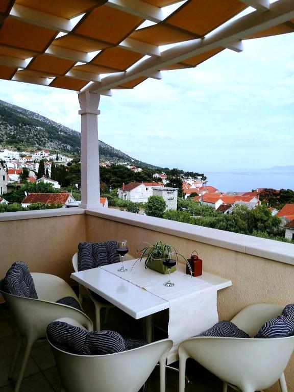 a table and chairs on a balcony with a view at Apartments Borovina in Bol