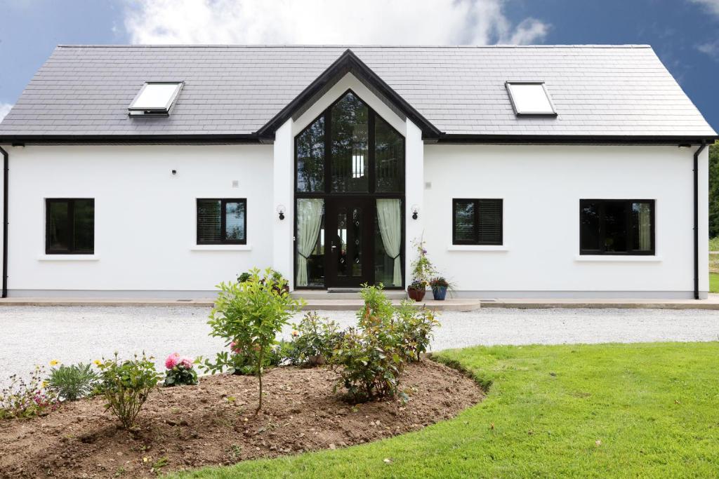 a white house with a black roof at Willoughby House in Cork