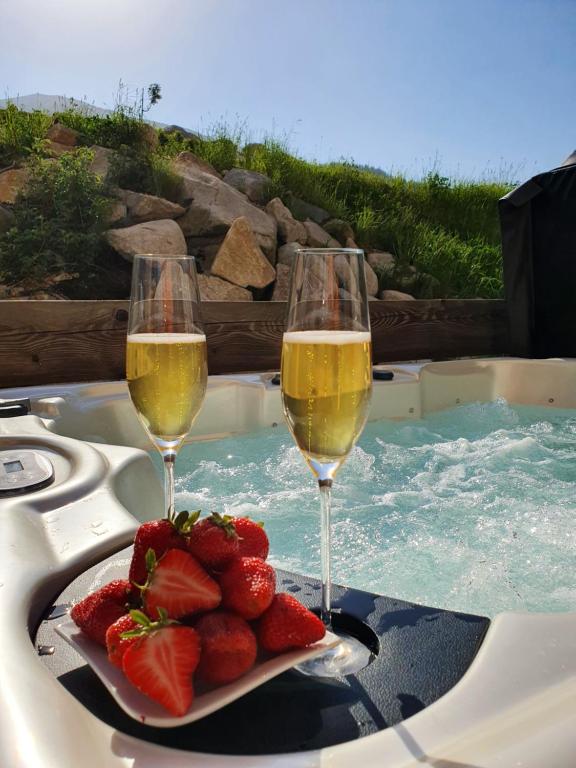 dos copas de champán y fresas en una piscina en Apartman EMMA, en Demänovská Dolina