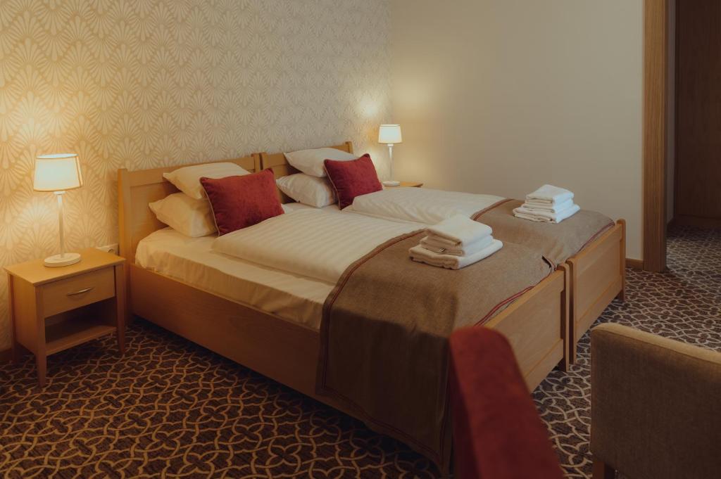 Postel nebo postele na pokoji v ubytování Brigadéros Hotel Brigadír Borsi