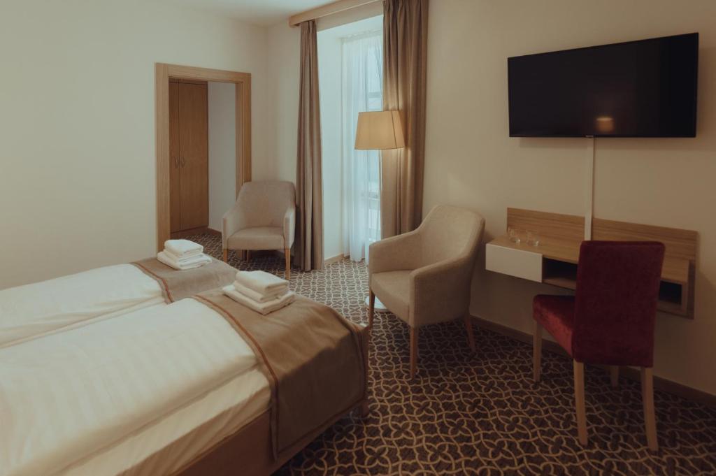 Postel nebo postele na pokoji v ubytování Brigadéros Hotel Brigadír Borsi