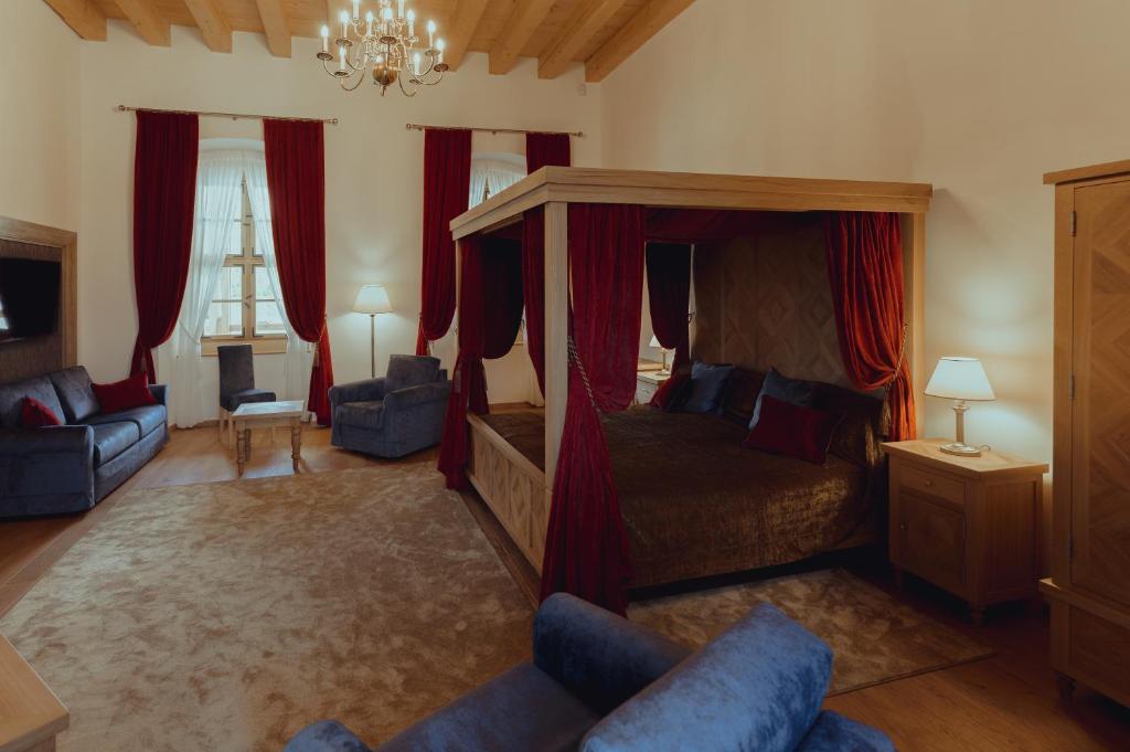 um quarto com uma cama de dossel e cortinas vermelhas em Brigadéros Hotel Brigadír Borsi em Borša
