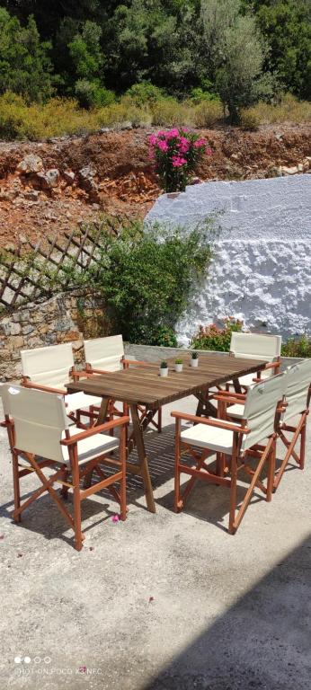 a wooden picnic table and four chairs around a table at Skalopati Studios & Villa in Panormos Skopelos