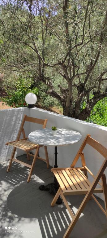 a table and two chairs sitting on a patio at Skalopati Studios & Villa in Panormos Skopelos