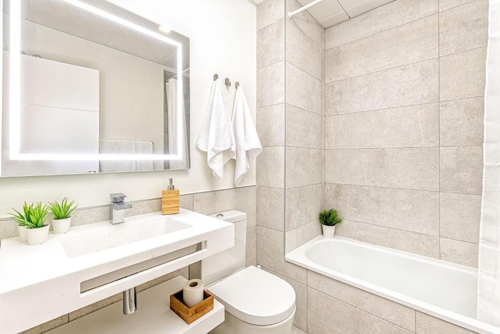 łazienka z umywalką, wanną i toaletą w obiekcie Teatro Apartment in Malaga by Solaga Holiday Homes w Maladze