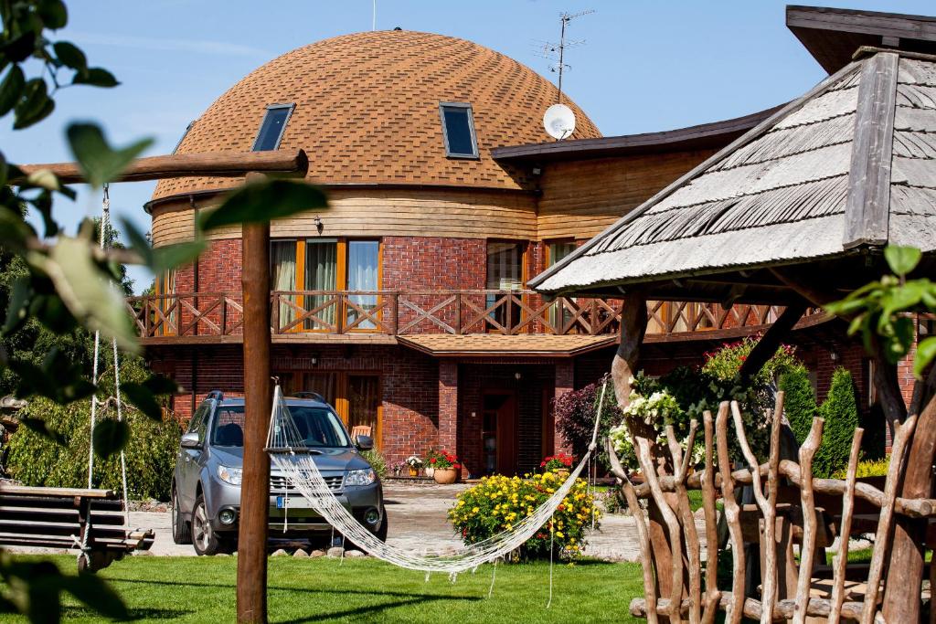 a house with a hammock in front of it at Vila Sraige in Palanga