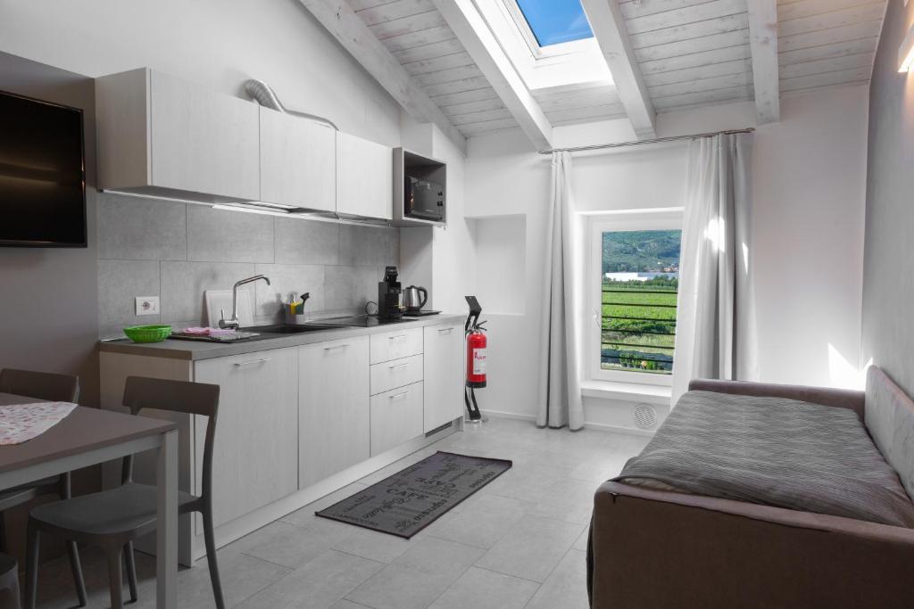 a kitchen with white cabinets and a table and a window at Appartamento Campagnola Mansardato in Riva del Garda