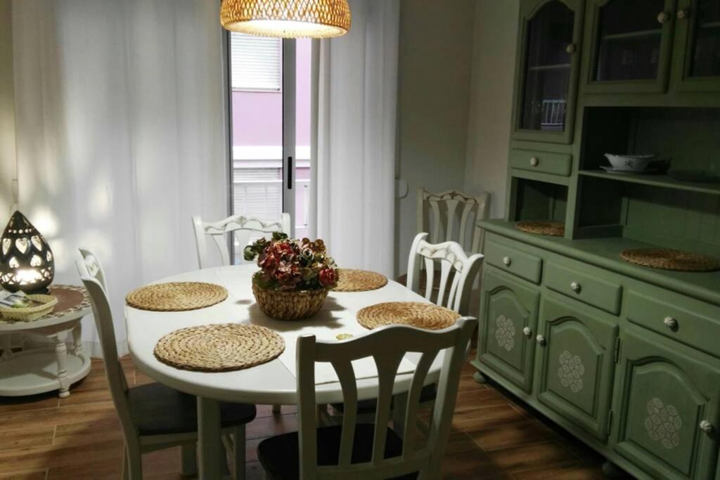 una cocina con una mesa blanca con sillas y una mesa con flores en Piso restaurado en Santa Cruz de La Palma, en Santa Cruz de la Palma