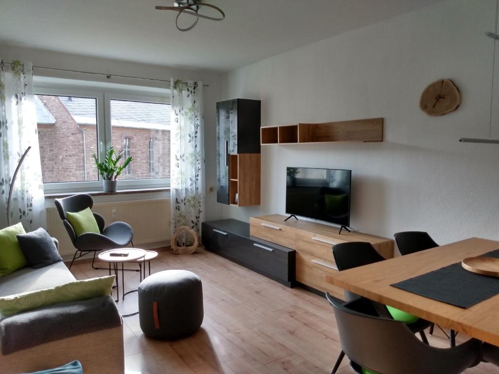 een woonkamer met een televisie en een tafel en stoelen bij Ferienwohnung Paula in Oberhof