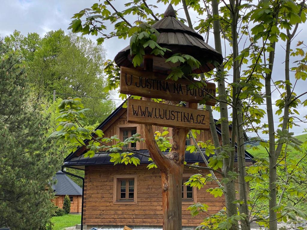 a sign in front of a wooden house at U Justina na potůčku in Velké Karlovice