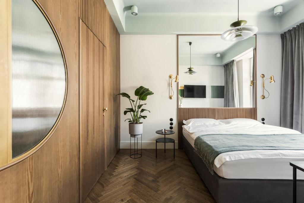 sypialnia z łóżkiem i dużym lustrem w obiekcie Angelus Apartments w Krakowie