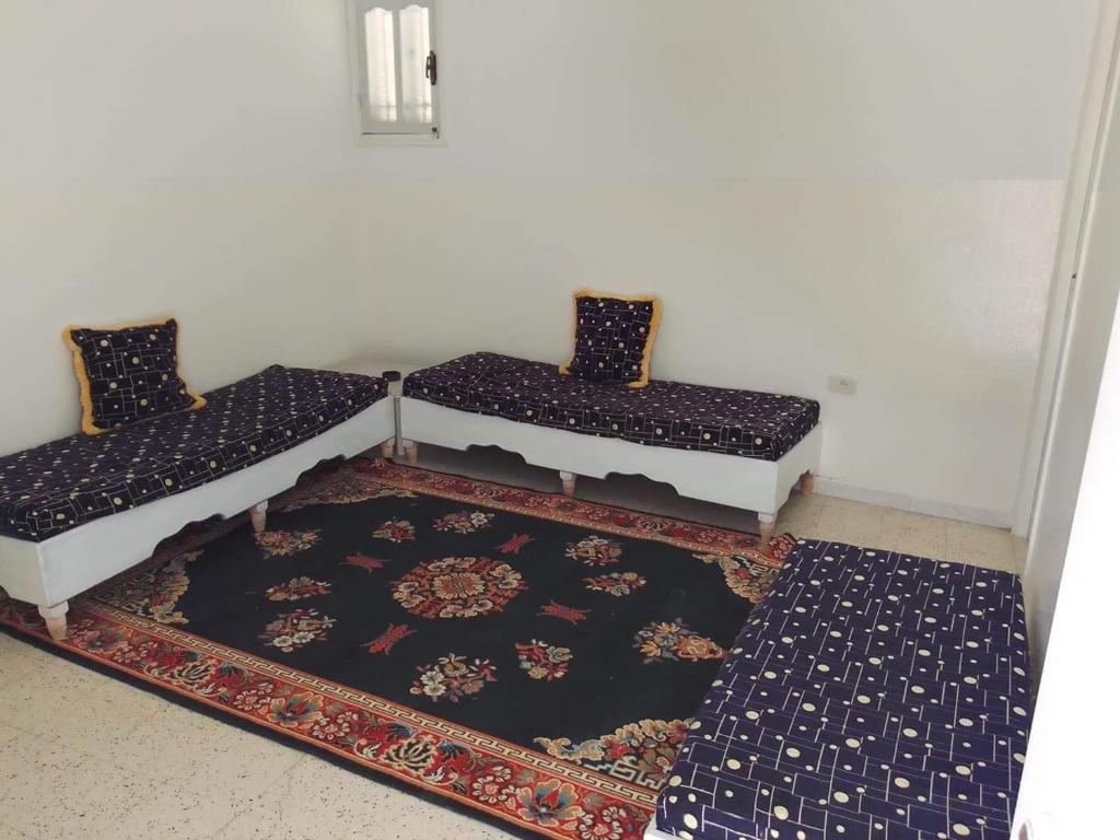 twee bedden in een kamer met een tapijt bij S+2 Beltaief Residence in Houmt Souk