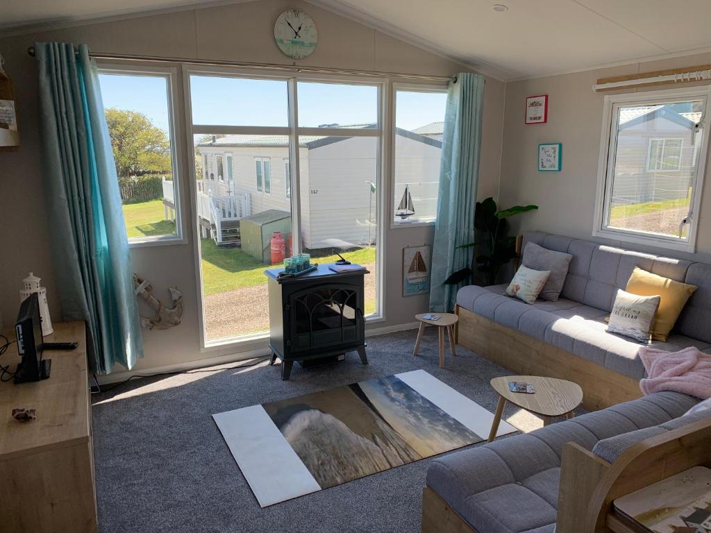 a living room with a couch and a stove at Bliss Beach Lodge Breath taking views in Bembridge
