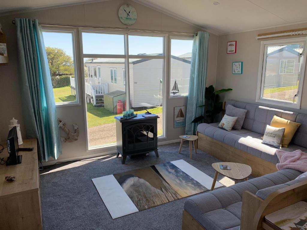 a living room with a couch and a stove at Bliss Beach Lodge in Bembridge