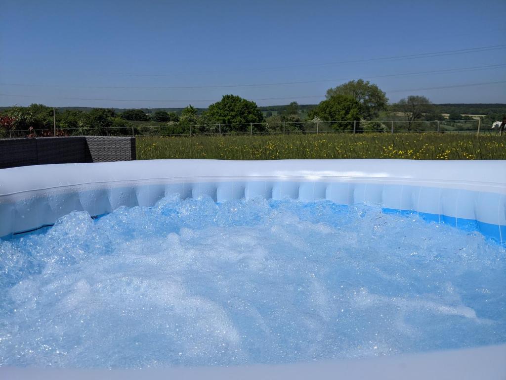 a hot tub filled with water in a backyard at Foxhill Lodges in Canterbury