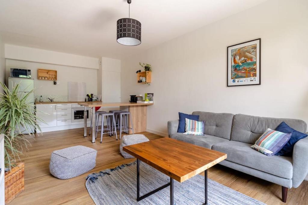 a living room with a couch and a table at La casa de Sophie T3 avec jardinet, Parking privé - Port de Vannes in Vannes