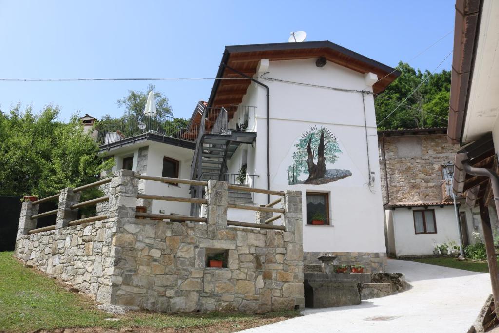 a house with a tree mural on the side of it at Casa del Castagno in Pulfero