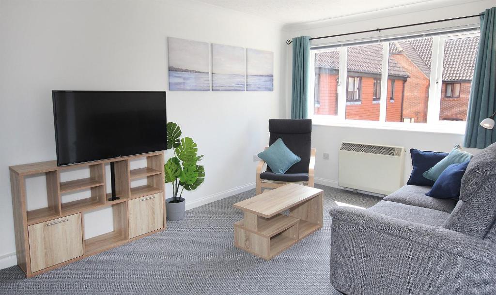 a living room with a couch and a television at ChiPad Mono - Comfy City Centre Apartment with Free Parking Space in Chichester