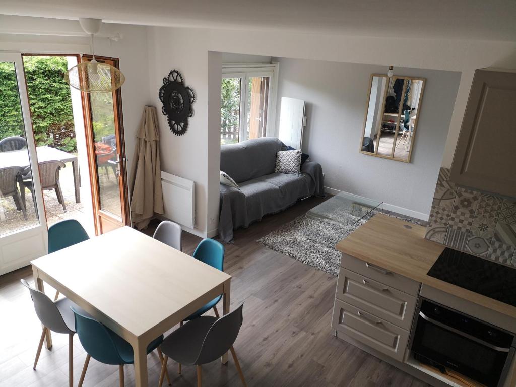 un salon avec une table, des chaises et un canapé dans l'établissement Les baigneurs, à Merville-Franceville-Plage