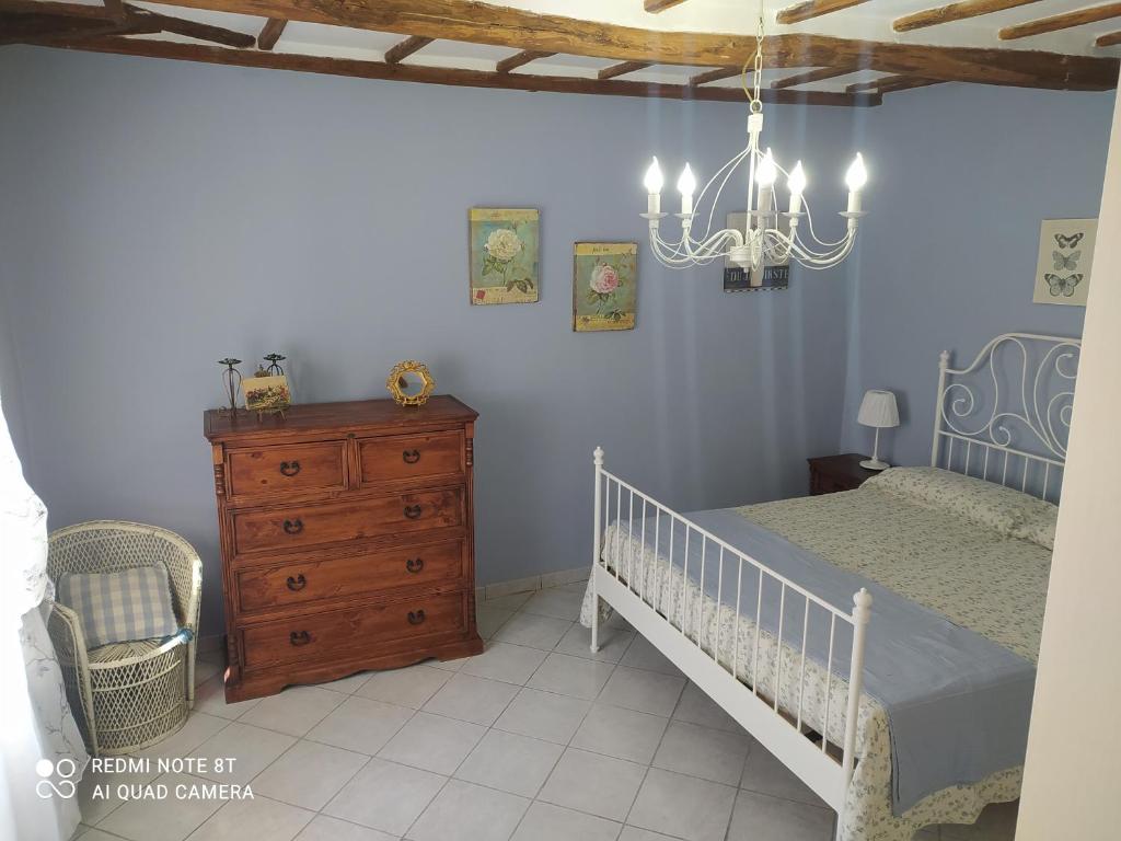 1 dormitorio con 1 cama, vestidor y lámpara de araña en Alloggio turistico Amalasunta, en San Lorenzo Nuovo