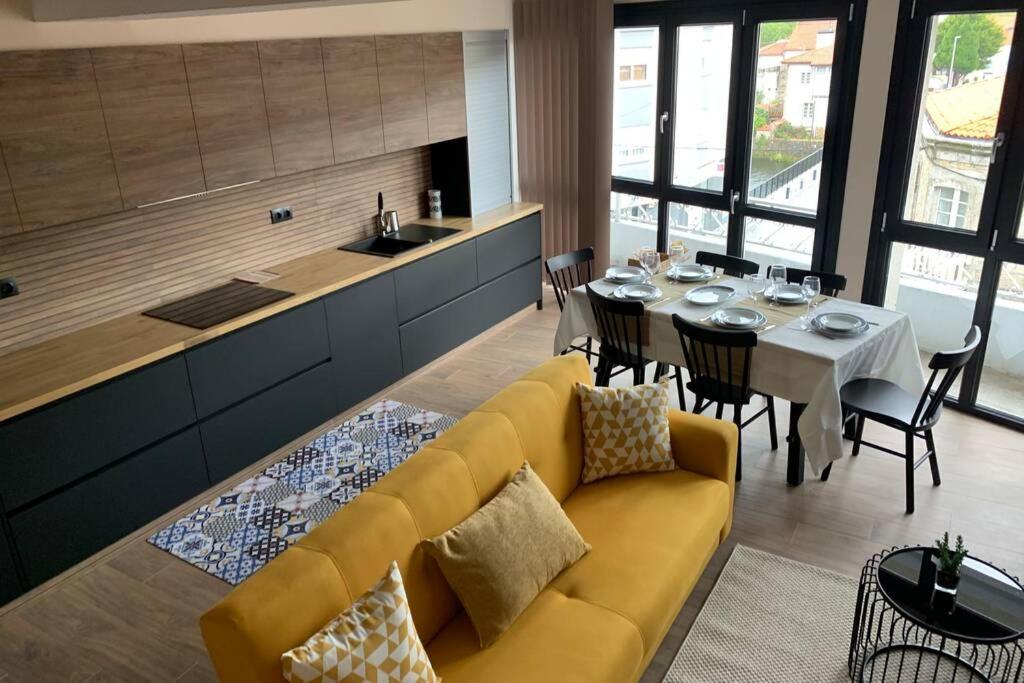 sala de estar con sofá amarillo y mesa en Duplex con terraza, en A Ponte do Porto