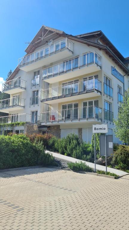 弦納的住宿－Apartament Czarna Góra B11，前面有标志的大型白色建筑
