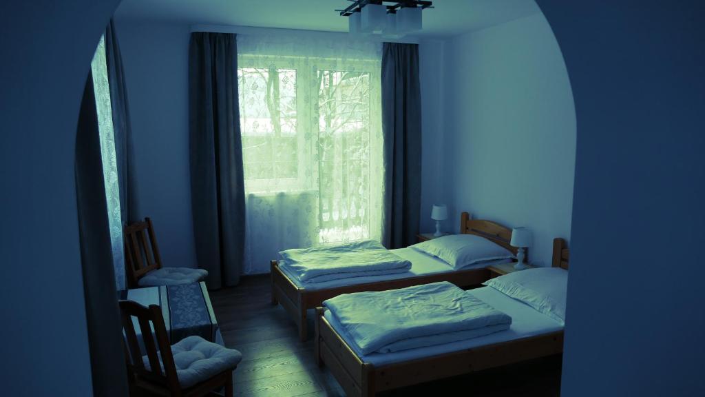 two beds in a room with a window at Apartamenty Bogusia Korbielów Pilsko in Korbielów