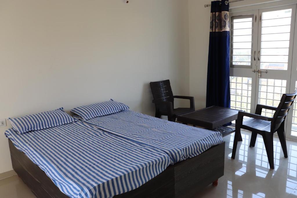 a bedroom with a bed and a table and chairs at Nature's Lap Homestay in Igatpuri